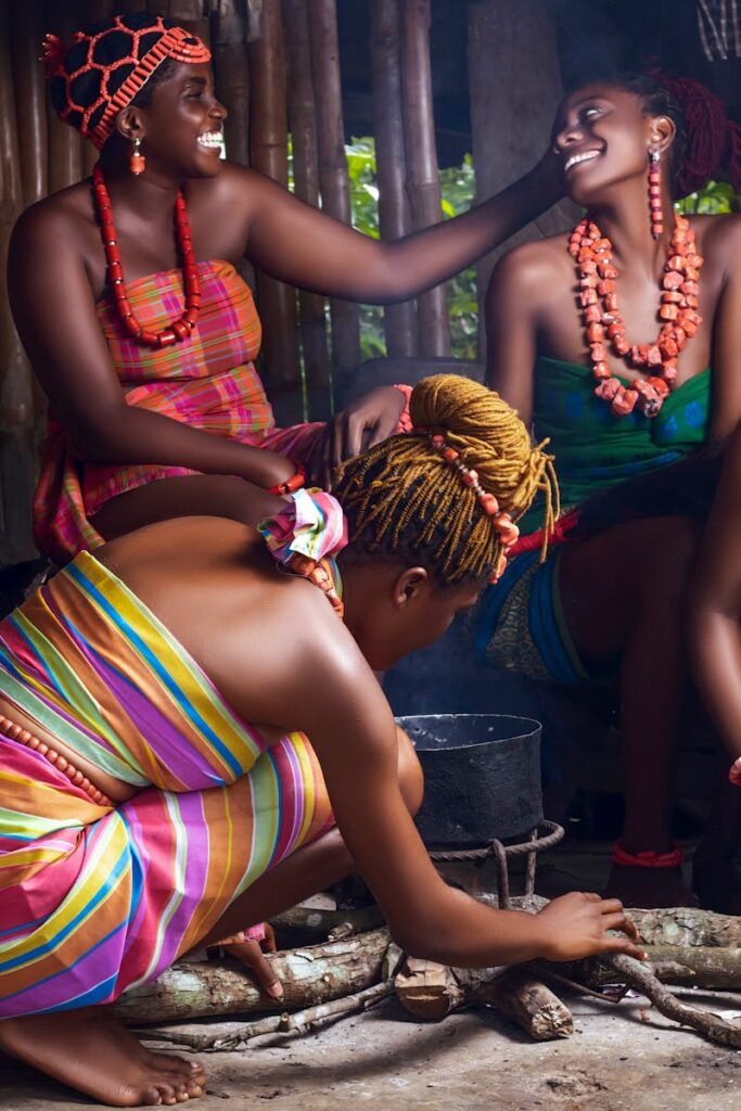 A vibrant scene of African women dressed in traditional attire, joyfully preparing a meal outdoors.